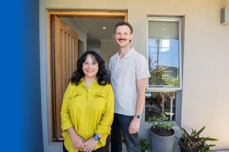 Two people standing at the front door of a house