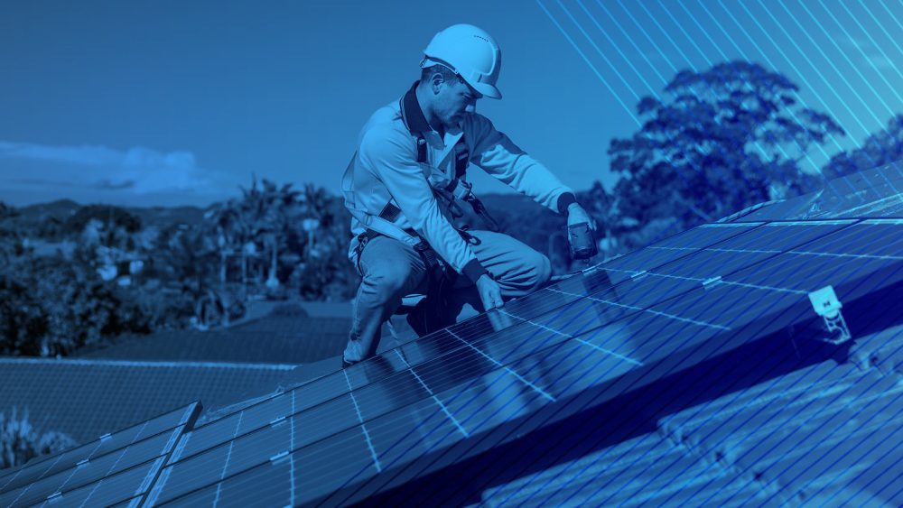 A person on a roof with solar panels.