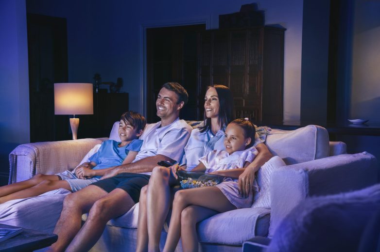 Family sitting on the couch watching TV