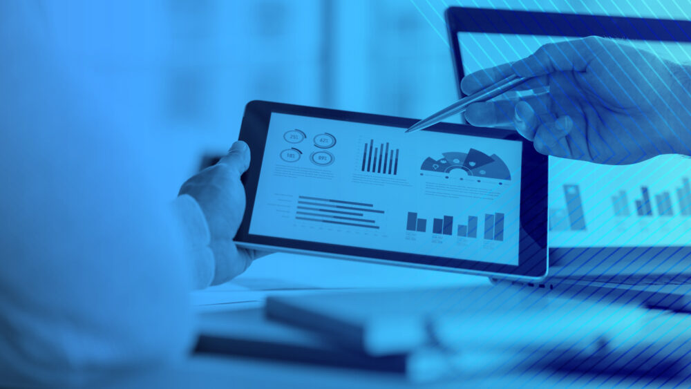 Photo of someone holding a tablet with graphs on it.
